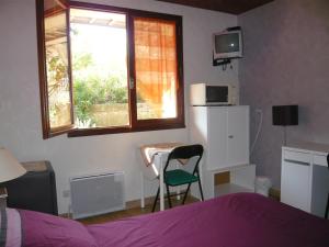 Schlafzimmer mit einem Bett, einem Tisch und einem Fenster in der Unterkunft MARC in Saint-Paul-Trois-Châteaux