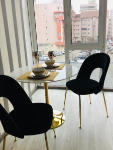 mesa y sillas en una habitación con ventana en Garsoniera centru pietonal en Târgu Jiu