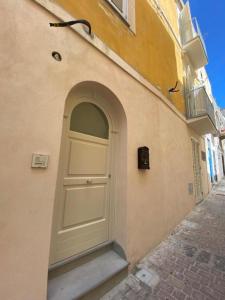 a white door on the side of a building at Appartamenti Holiday Housing Lipari Centro in Lipari