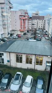 a parking lot with cars parked in front of a building at Garsoniera centru pietonal in Târgu Jiu