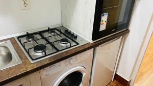 a stove top oven sitting next to a washing machine at Garsoniera centru pietonal in Târgu Jiu