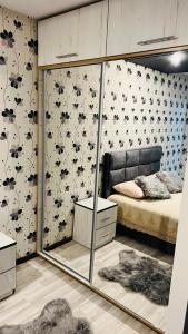 a bedroom with a bed and a mirror at Garsoniera centru pietonal in Târgu Jiu