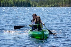 un hombre y una chica en un kayak en un lago en Vildmarks Lodge, en Ytterhogdal