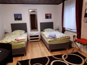 um quarto com 2 camas e um espelho em Gästehaus UP-Arnold em Pinneberg
