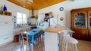 a kitchen with white appliances and a wooden ceiling at Villa La Grande Vallée in Saint-Gilles-Croix-de-Vie