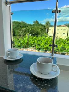 2 tasses à café assises sur une table sur un balcon dans l'établissement Hermoso Apartamento en Santiago, à Santiago de los Caballeros