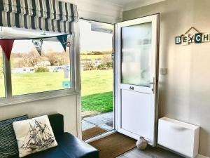 una puerta a un porche con vistas a un campo en Wight Waves Holidays en Sandown