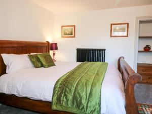 ein Schlafzimmer mit einem Bett mit einer grünen Decke darauf in der Unterkunft Mill View Duplex in Mansfield