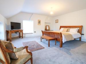 Schlafzimmer mit einem Bett, einem TV und einem Stuhl in der Unterkunft Mill View Duplex in Mansfield