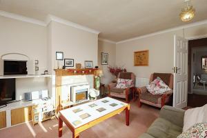 a living room with a couch and a fireplace at Whitestones in Brighstone