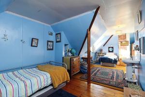 a bedroom with blue walls and a bed and a sink at Whitestones in Brighstone