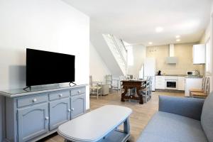 a living room with a tv on a blue cabinet at Casa de 10 Dúplex in Vejer de la Frontera