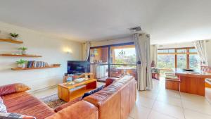 a living room with a couch and a television at San Lameer 3123 by Top Destinations Rentals in Southbroom