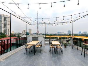 a patio with tables and chairs on a roof with lights at Muse Hanoi Boutique Apartment in Hanoi