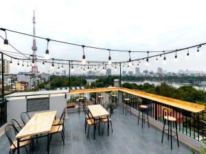 a rooftop deck with tables and chairs and lights at Muse Hanoi Boutique Apartment in Hanoi