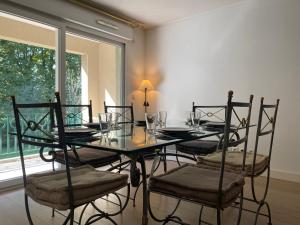 une salle à manger avec une table et des chaises en verre dans l'établissement La Pommeray Geneva, à Veigy-Foncenex