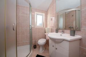 une salle de bains avec toilettes, lavabo et douche dans l'établissement Apartmani Luka, à Rab 64 autres photos