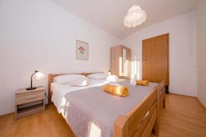 - une chambre dotée d'un grand lit avec un sac jaune dans l'établissement Apartmani Luka, à Rab