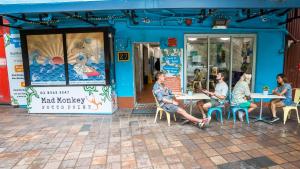 Un grupo de personas sentadas en mesas afuera de un restaurante. en Mad Monkey Potts Point, en Sídney