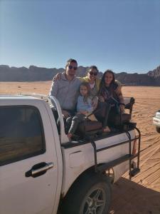 a group of people sitting in the back of a truck at Rum Aranda camp & Jeep Tour in Wadi Rum
