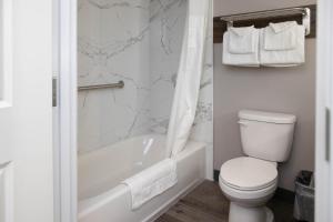 a bathroom with a toilet and a tub and a sink at Motel 6 Highland CA San Bernardino East in Highland