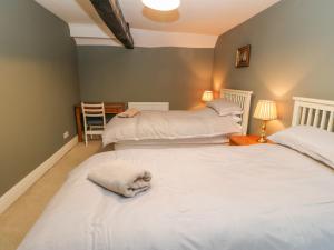 a bedroom with two beds with towels on them at Firkin Cottage in Bedale