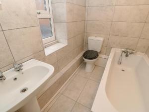 a bathroom with a sink and a toilet and a tub at Firkin Cottage in Bedale +12 photos