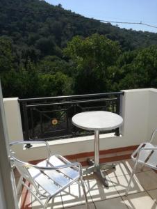 a table and chairs on a balcony with a view at MIRSINI HOTEL in Plomari