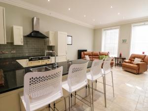 a kitchen with white chairs and a counter top at Cotton Mill Cottage in Mansfield