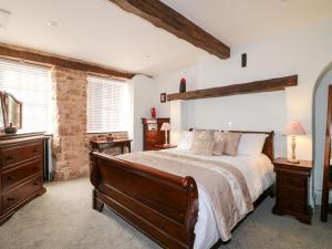 a bedroom with a large bed and two windows at Cotton Mill Cottage in Mansfield