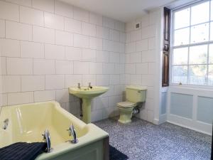 a bathroom with a sink and a tub and a toilet at Cotton Mill Cottage in Mansfield