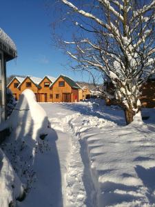 a driveway covered in snow in front of a house at Domki "Berenika" in Rewal