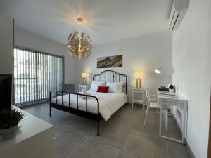 a bedroom with a bed and a table and a desk at Casa Leon Malta in St. Julianʼs