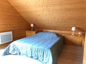 a bedroom with a bed in a wooden cabin at Chalet Myrtille in Gérardmer