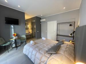 a bedroom with a large bed and a table and a room at Dimora San Gregorio Luxury Rooms in Palermo