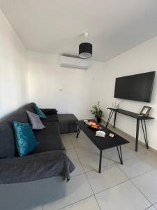 ein Wohnzimmer mit einem Sofa und einem Tisch in der Unterkunft Cielo Apartment No2 in Ayia Napa