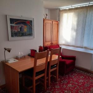 Habitación con mesa de madera y silla roja. en The John Rand Suite, en Samobor