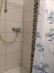 a bathroom with a shower curtain with birds on it at Kleine Ferienwohnung in Vöhringen