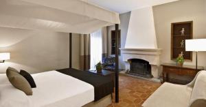 a bedroom with a bed and a fireplace at La Almoraima Hotel in Castellar de la Frontera