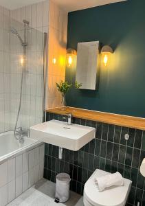a bathroom with a sink and a toilet and a mirror at Margate Seaside Haven With 2 Terraces Sleeps 6 in Kent