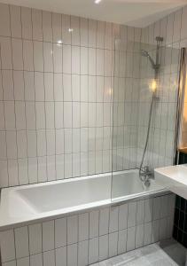 a bath tub in a bathroom with a shower at Margate Seaside Haven With 2 Terraces Sleeps 6 in Kent