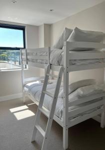 a room with two bunk beds and a window at Margate Seaside Haven With 2 Terraces Sleeps 6 in Kent
