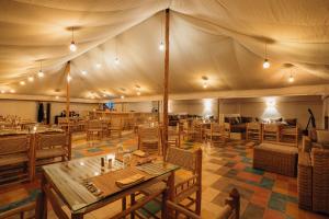 ein Zelt mit Tischen und Stühlen in einem Restaurant in der Unterkunft Oxygen Lodge Agafay in El Karia