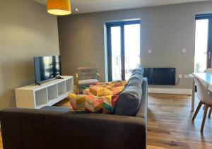 a living room with a couch and a flat screen tv at Margate Seaside Haven With 2 Terraces Sleeps 6 in Kent