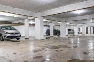 a parking garage with two cars parked in it at Blumenau Tower by Castelo Itaipava in Blumenau +49 photos