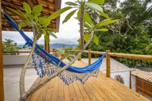 a hammock on the deck of a house at Suítes Casa Maembippe in Ilhabela