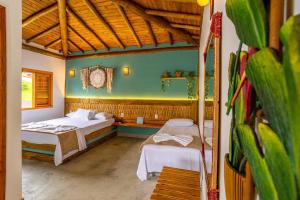 Un dormitorio con dos camas y una pared verde. en Suítes Casa Maembippe, en Ilhabela