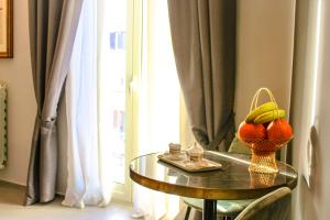 a table with a basket of fruit on it next to a window at Dimora San Gregorio Luxury Rooms in Palermo