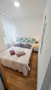 - une chambre avec un lit doté d'oreillers violets dans l'établissement Appartements cosy BELFORT, à Belfort