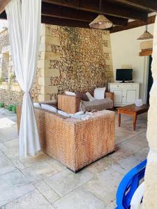 un gran sofá de mimbre sentado en un patio en Villa Delfino, en San Foca